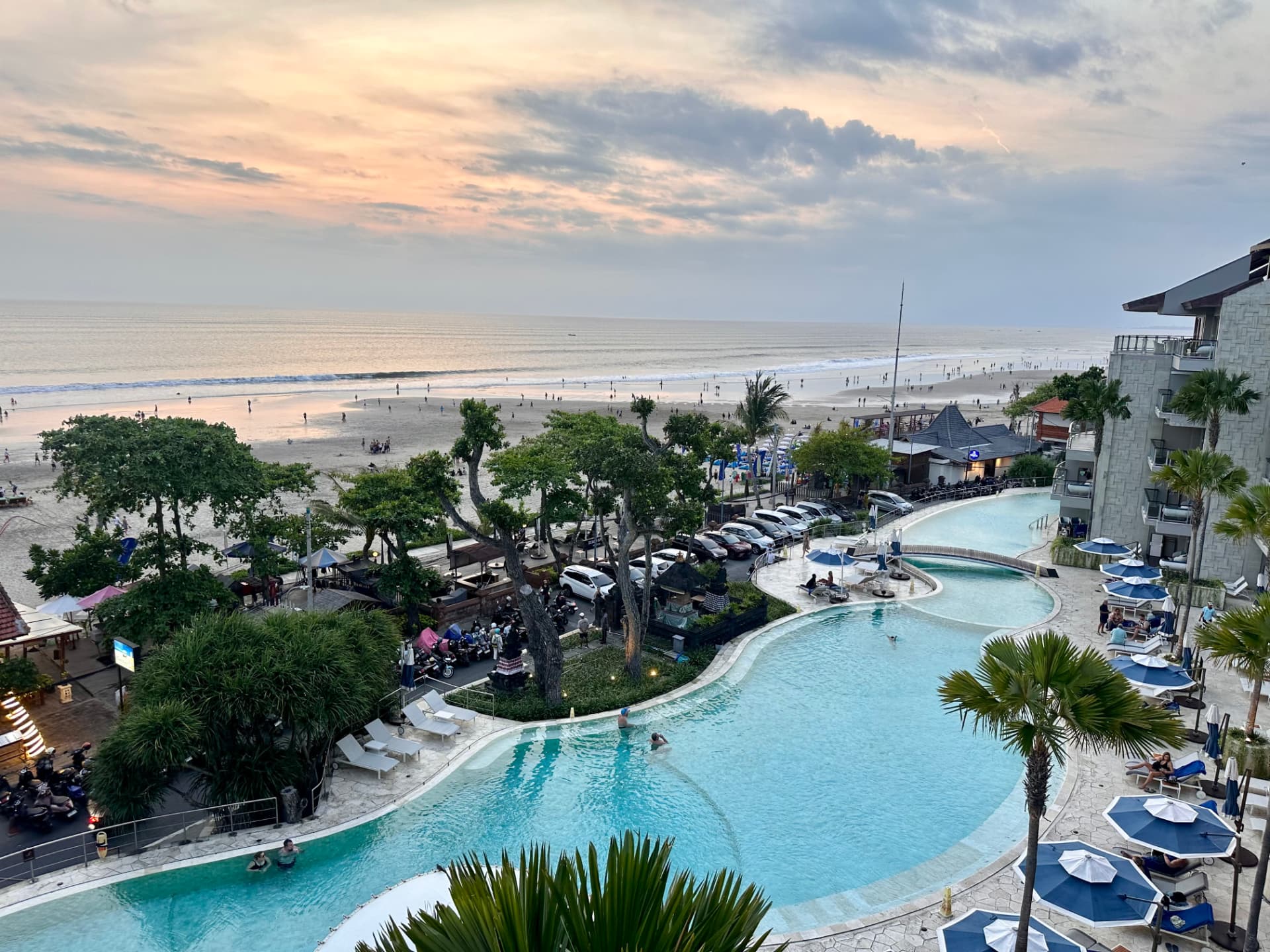 Sunset over Seminyak beach seen from a resort pool terrace in Bali