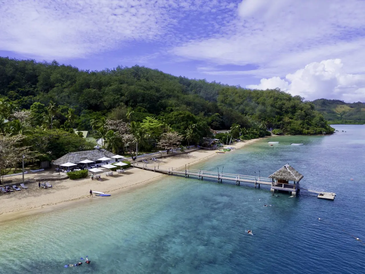 Aerial view of a Fijian beach, jetty and fringing reef
