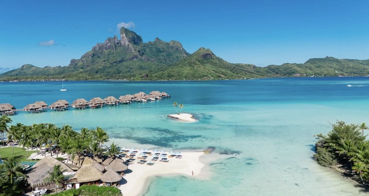 Bora Bora's volcanic peaks rising beyond a turquoise lagoon and overwater bungalows